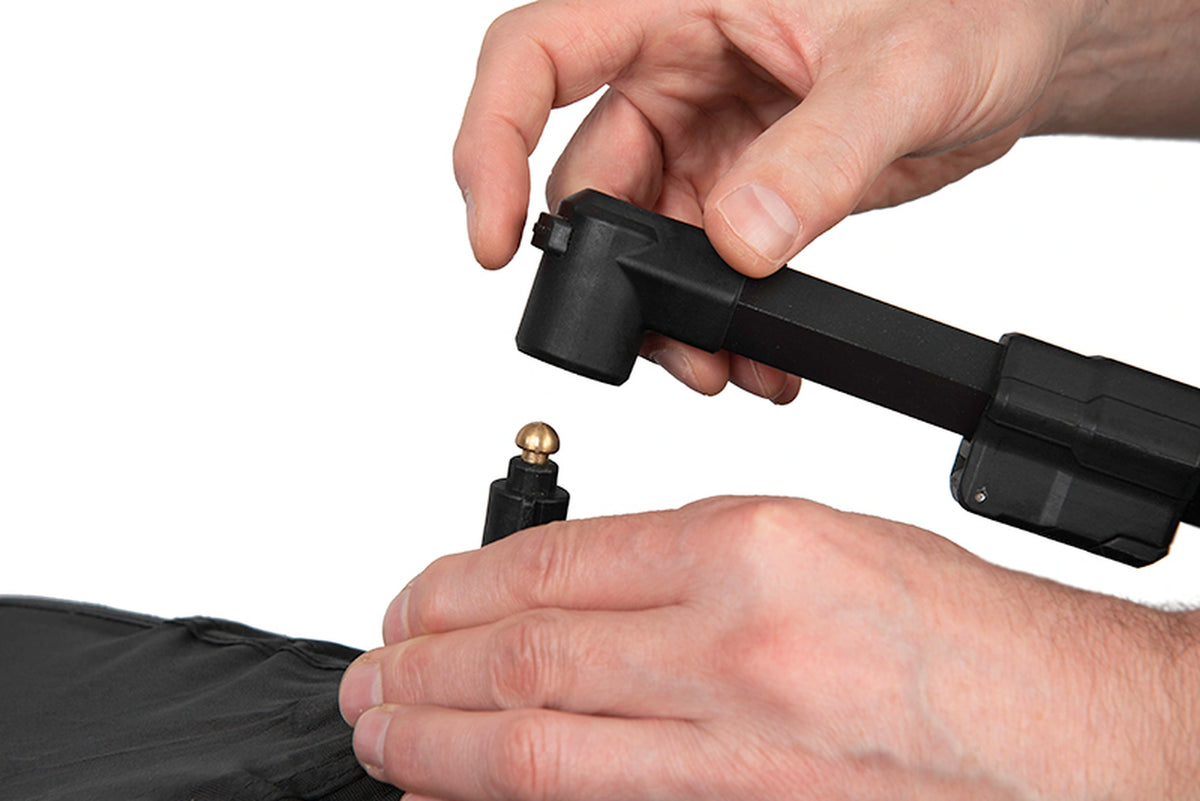 Matrix Pro Bait Brolly – handen tonen de ontgrendelknop en losgenomen verbinding tussen steunarm en paraplukap