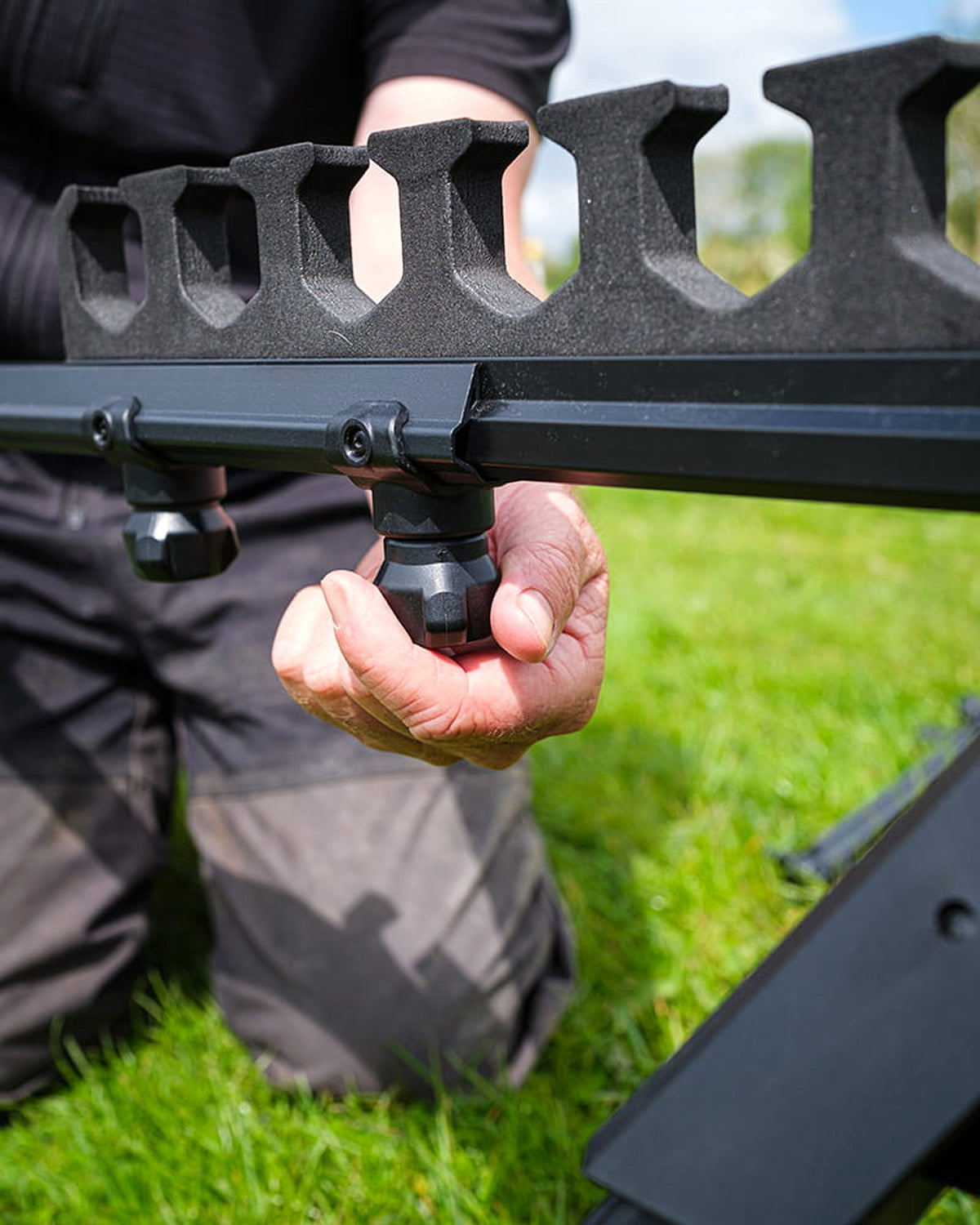 Matrix Roost Distance Sticks – hand draait de bevestigingsknop aan tijdens montage aan de oever
