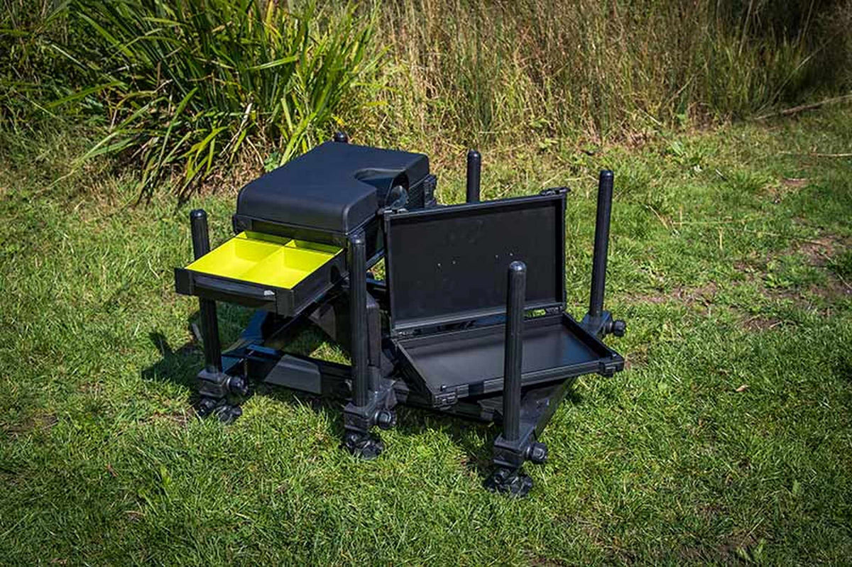 Matrix S36 Pro Black zitkist op gras met uitgeschoven gele lade en geopende opbergmodule