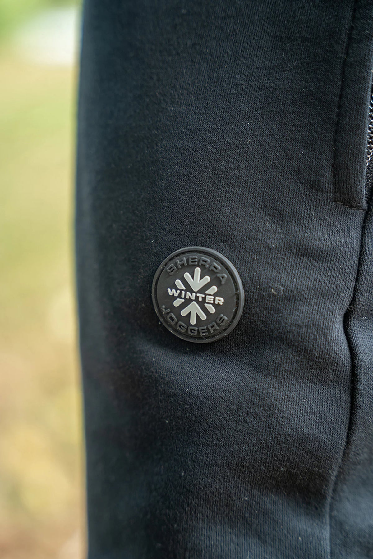 Matrix Sherpa Joggers – detail van de ronde Sherpa Winter Joggers-badge op de zwarte broek, buiten gefotografeerd