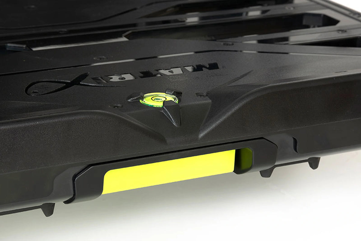 Matrix XR36 Pro Shadow Seatbox – detail van het zwarte voetplateau met Matrix-logo, ingebouwde waterpas en gele voorstrook