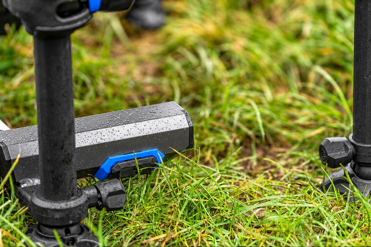 Detail van het natte frame met blauwe handgreep en pootklemmen van de Preston Absolute 5G 360-zitkist in het gras