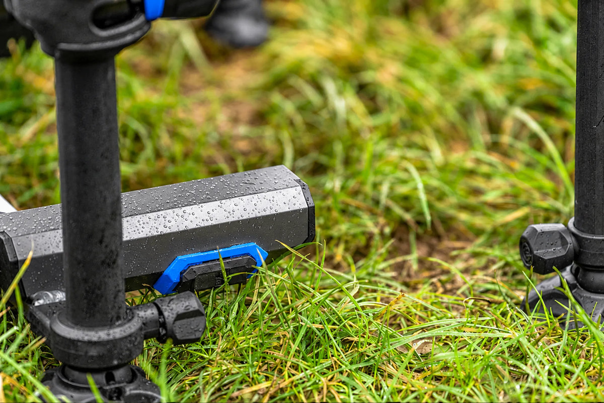 Detail van het natte frame met blauwe handgreep en pootklemmen van de Preston Absolute 5G 360-zitkist in het gras