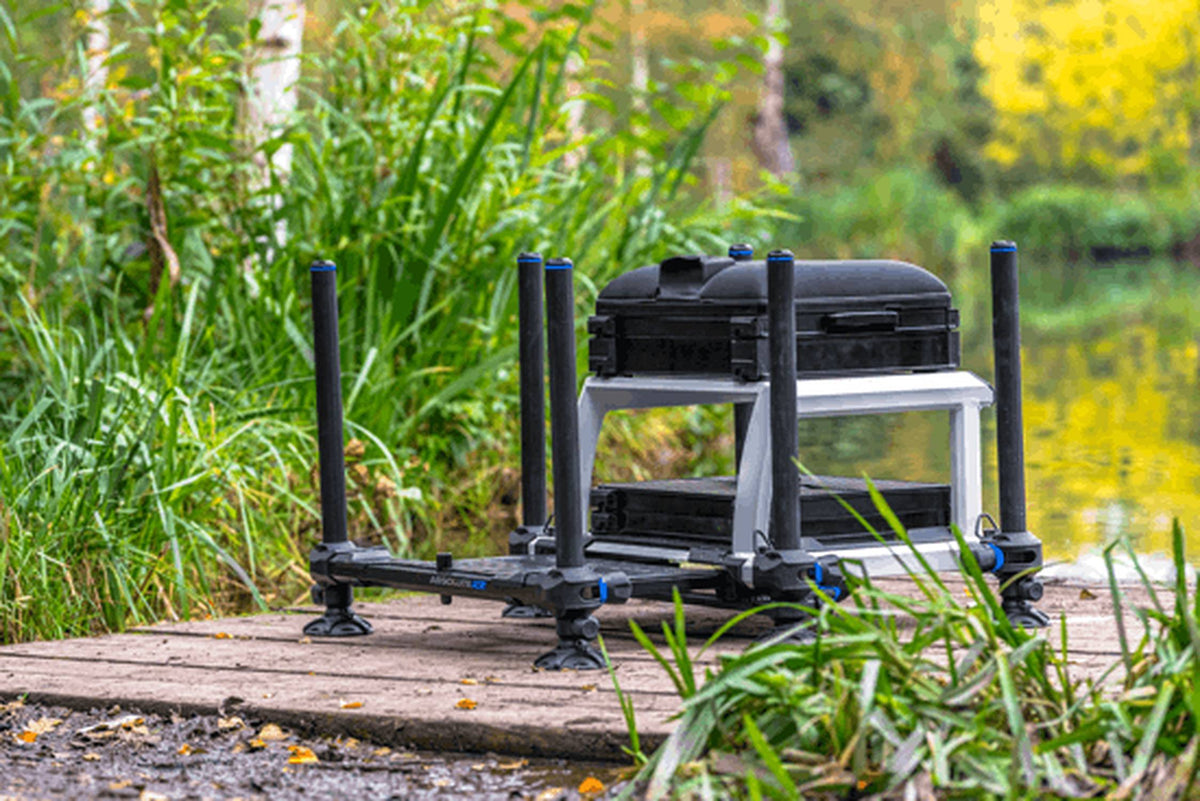 Preston Absolute 5G Station – laag vooraanzicht van de uitvoering met zilverkleurig frame naast het riet op de steiger