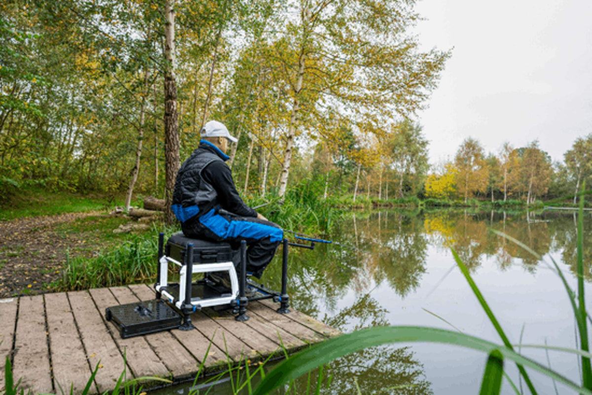Preston Absolute 5G Station – visser op de uitvoering met zilverkleurig frame aan het water, vanaf de steiger gezien