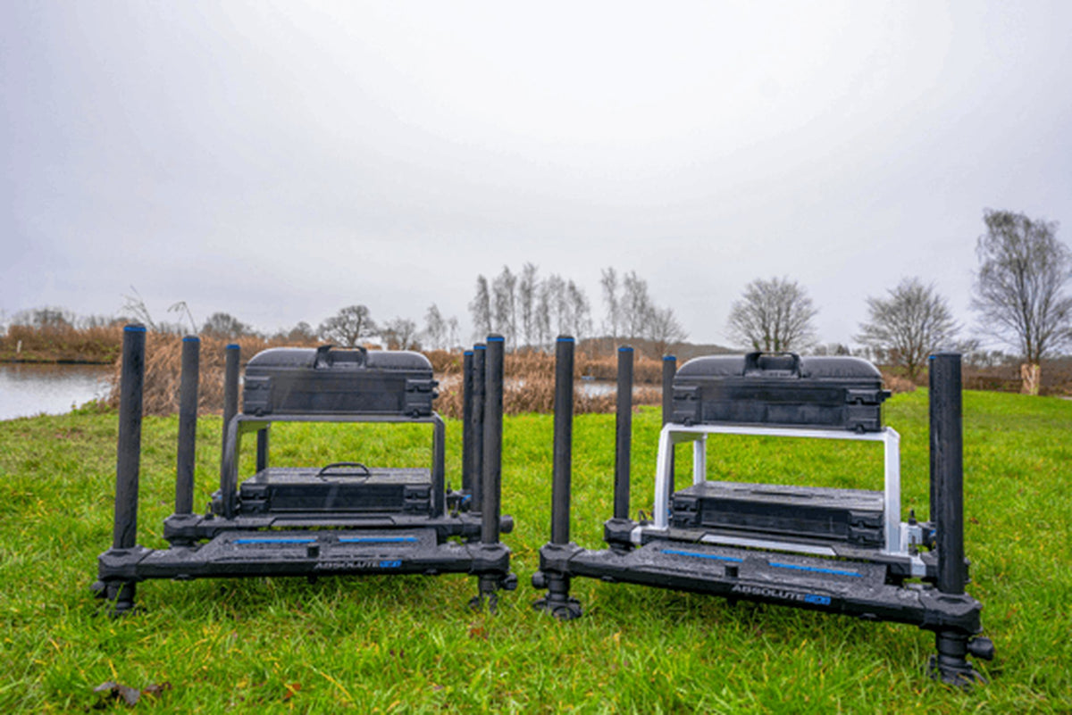 Preston Absolute 5G Station – zwarte en zilverkleurige uitvoering naast elkaar op het gras bij de vijver