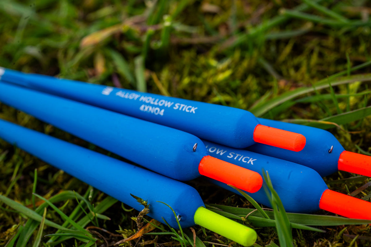 Preston Alloy Hollow Stick dobbers met felgekleurde antennes liggend in het gras