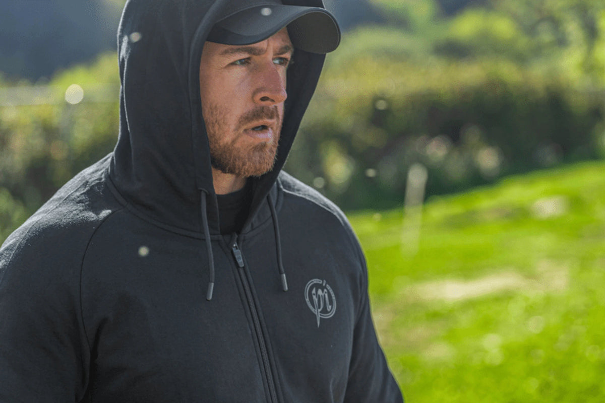 Preston Core Collection Zip Hoodie gedragen met de capuchon omhoog over een pet, detail van borst en schouders