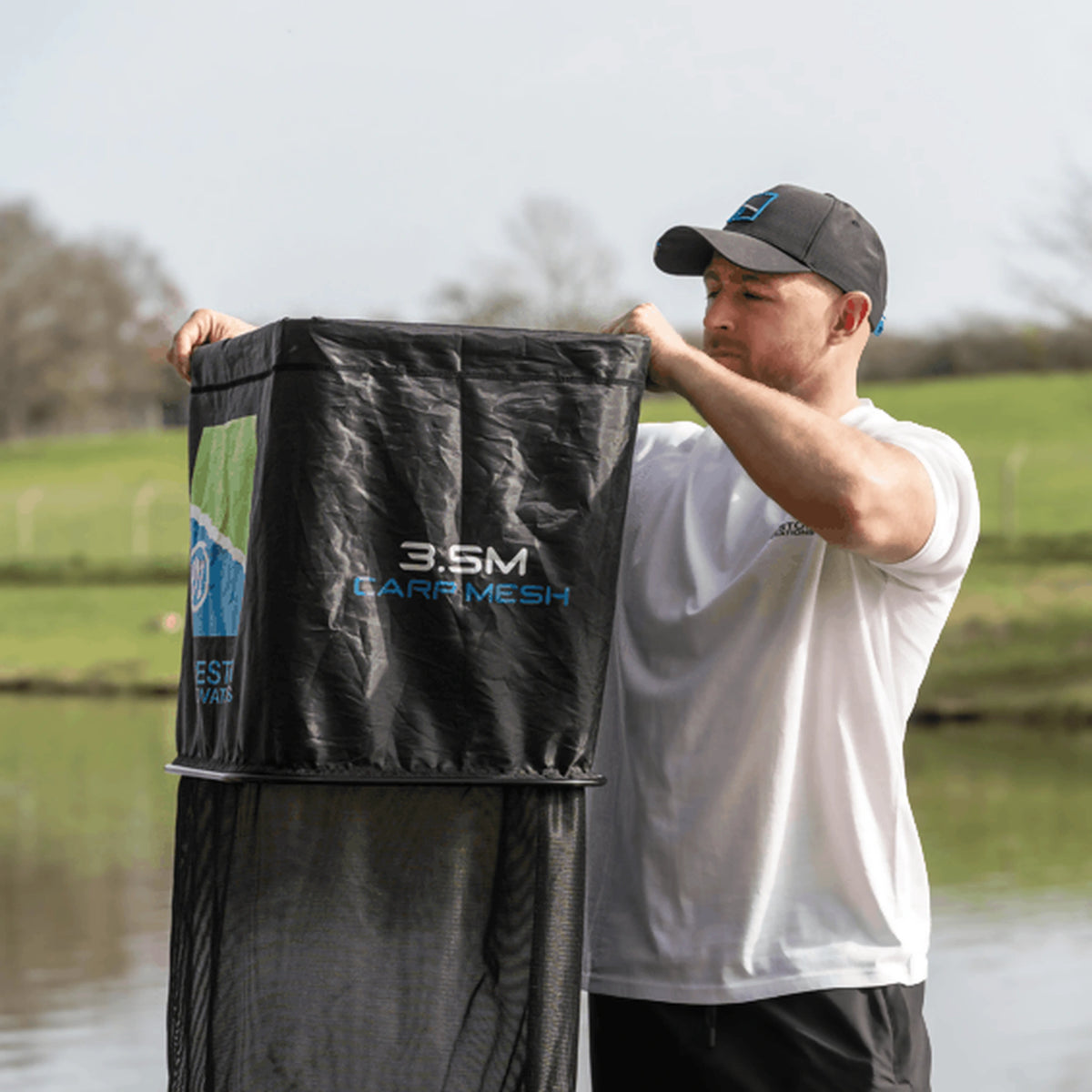 Preston Dura Keepnets 3,5 m Carp Mesh – visser houdt het leefnet omhoog aan de waterkant