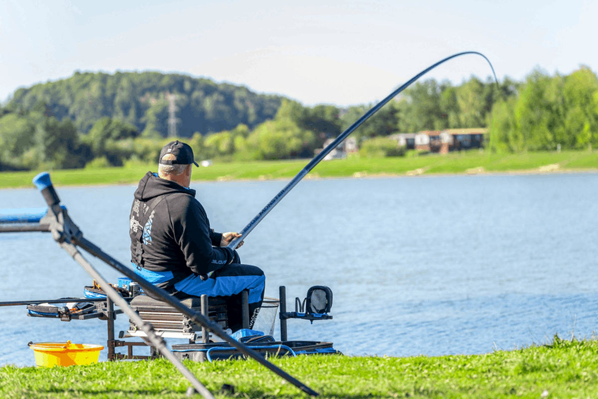 Preston Edge Monster Margin 11m – visser met omhoog gebogen hengel, schuin van achteren gezien