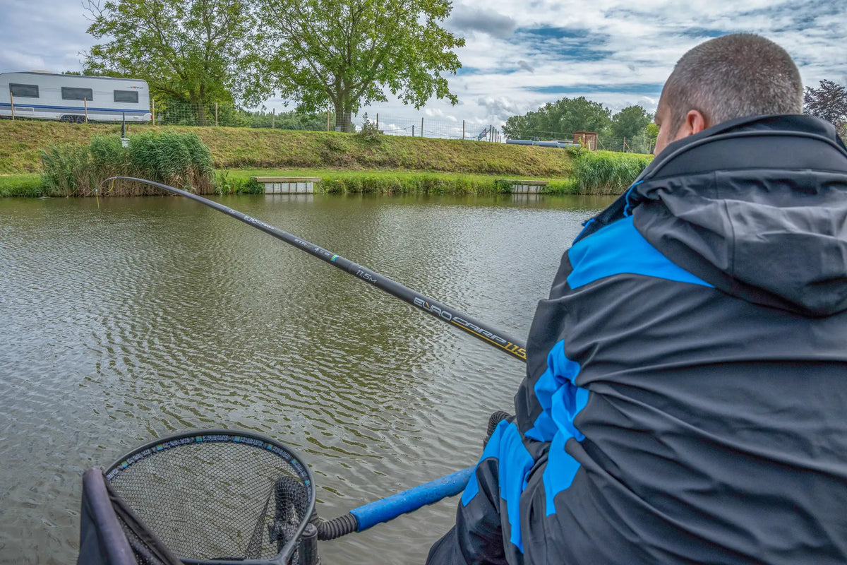 Preston Euro Carp 1150 STR S tijdens het vissen, gezien schuin achter de visser