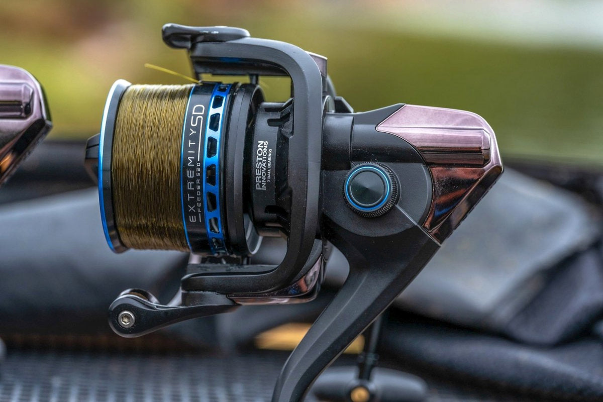 Zijaanzicht van de Preston Extremity SD 520 feedermolen met opgespoelde lijn en bronzen behuizingsdeel