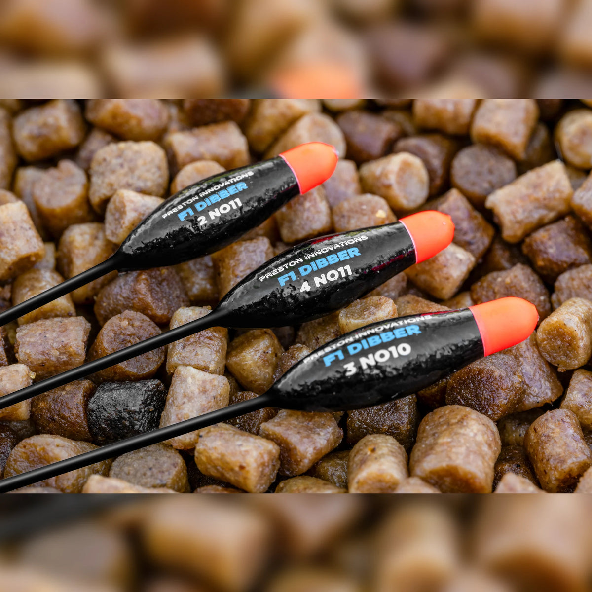 Preston F1 Dibber – drie F1 Dibber dobbers diagonaal op pellets, detail van lichaam en opdruk