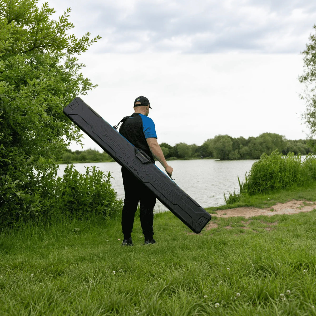 Visser draagt Preston Hardcase Pole Safe XL langs het water