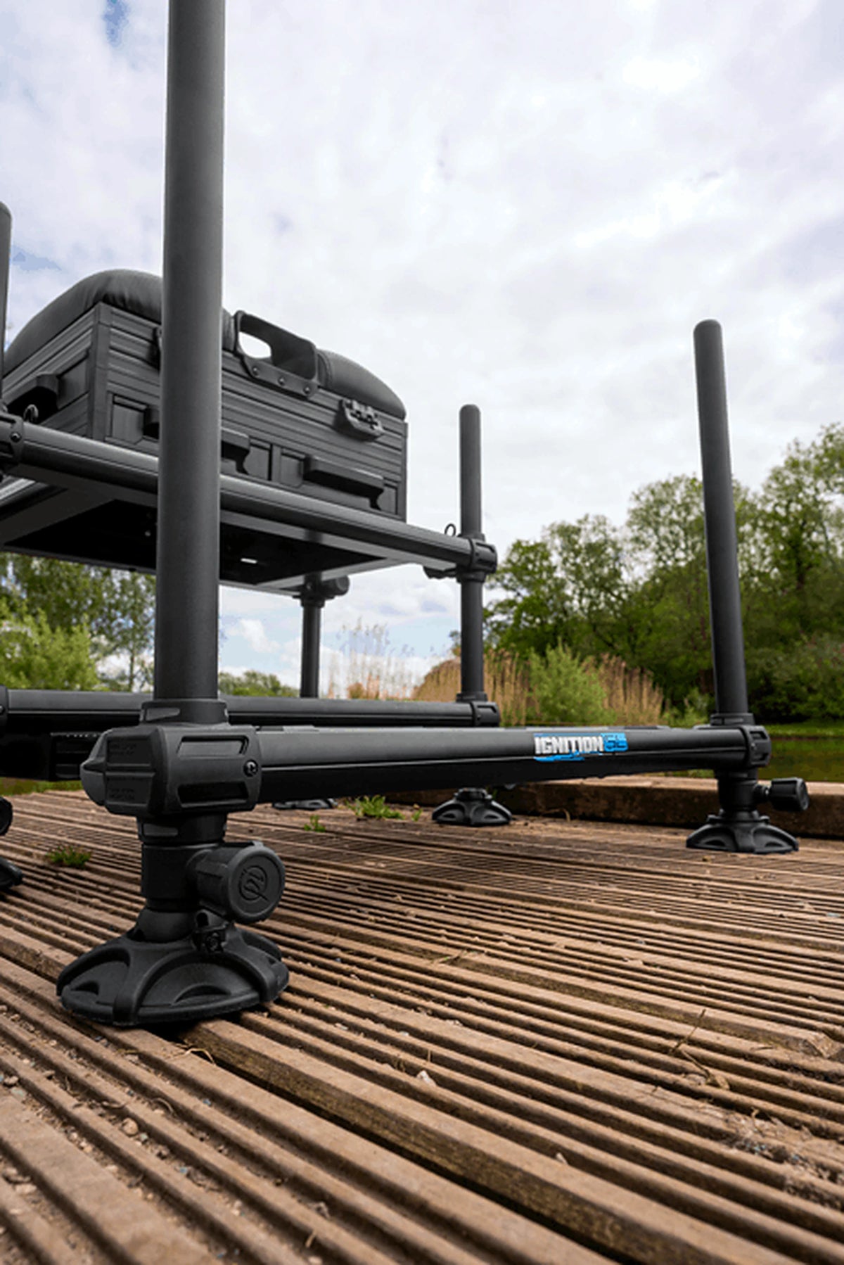 Preston Ignition SL Seatbox – laag zijaanzicht van pootklem, stelknop en moddervoet op de houten steiger