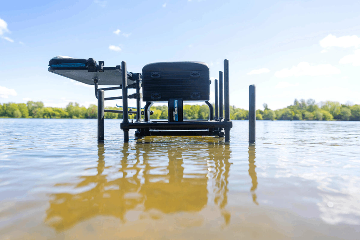 Preston Ignition Station SL Seatbox – gebruiksvoorbeeld van de zitkist met uitgeschoven voetplaat en gemonteerde aastafel in ondiep water