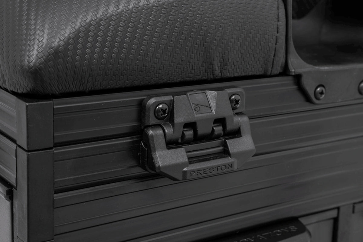 Preston Ignition Station SL Seatbox – detail van de Preston-sluitclip onder de gevoerde zitting en de aansluiting van de lademeubels