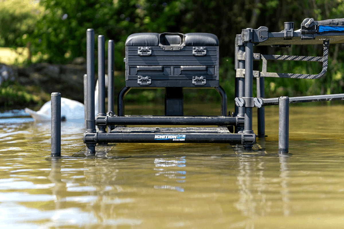 Preston Ignition Station SL Seatbox – vooraanzicht van de zitkist met frontlades, verstelbare poten en voetplaat in ondiep water