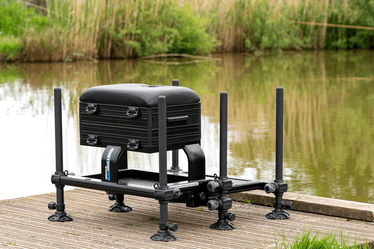 Preston Ignition Station SL Seatbox – volledige zitkist met verstelbare poten en voetplaat op een houten steiger