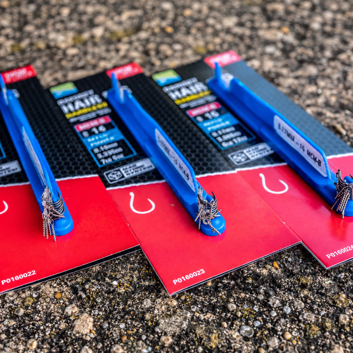 Detailfoto van drie Preston MCM-B Bayonet Hair Rig-verpakkingen met blauwe Mag Store-sticks en metalen aasbayonets