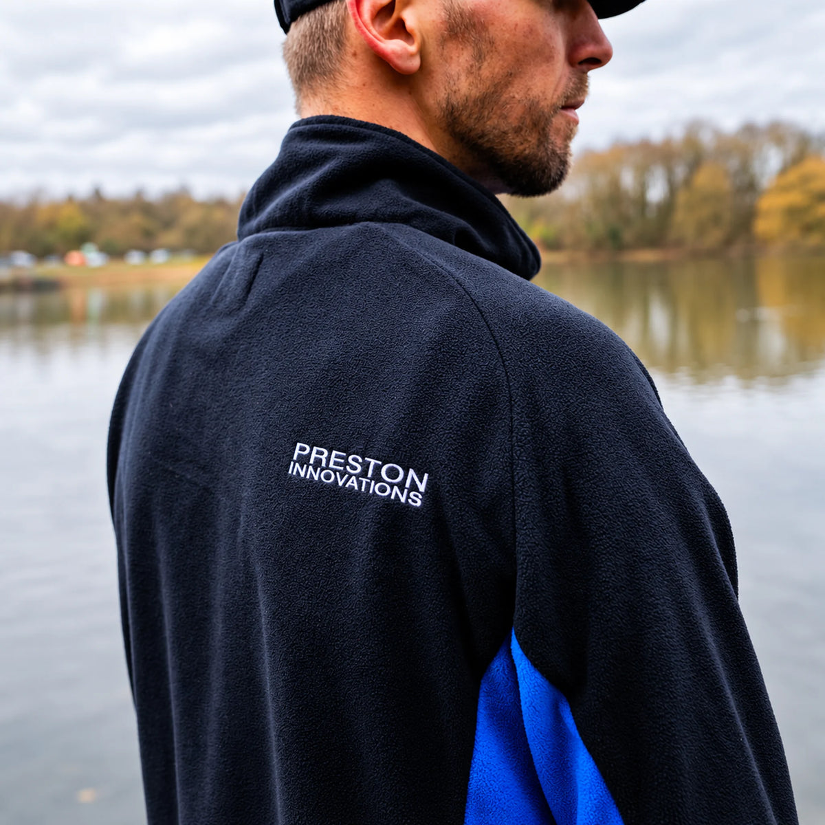 Preston Micro Fleece, detail van de rugborduring, schoudernaad en blauwe zijpanelen tijdens het dragen