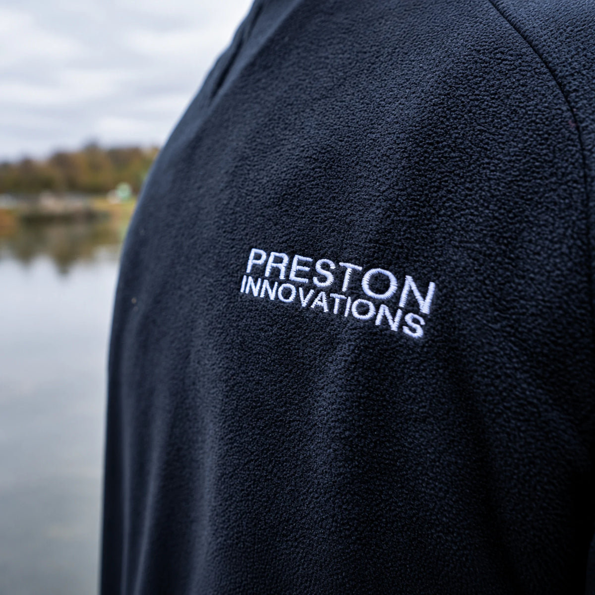 Preston Micro Fleece, close-up van de witte Preston Innovations-borduring op de rug
