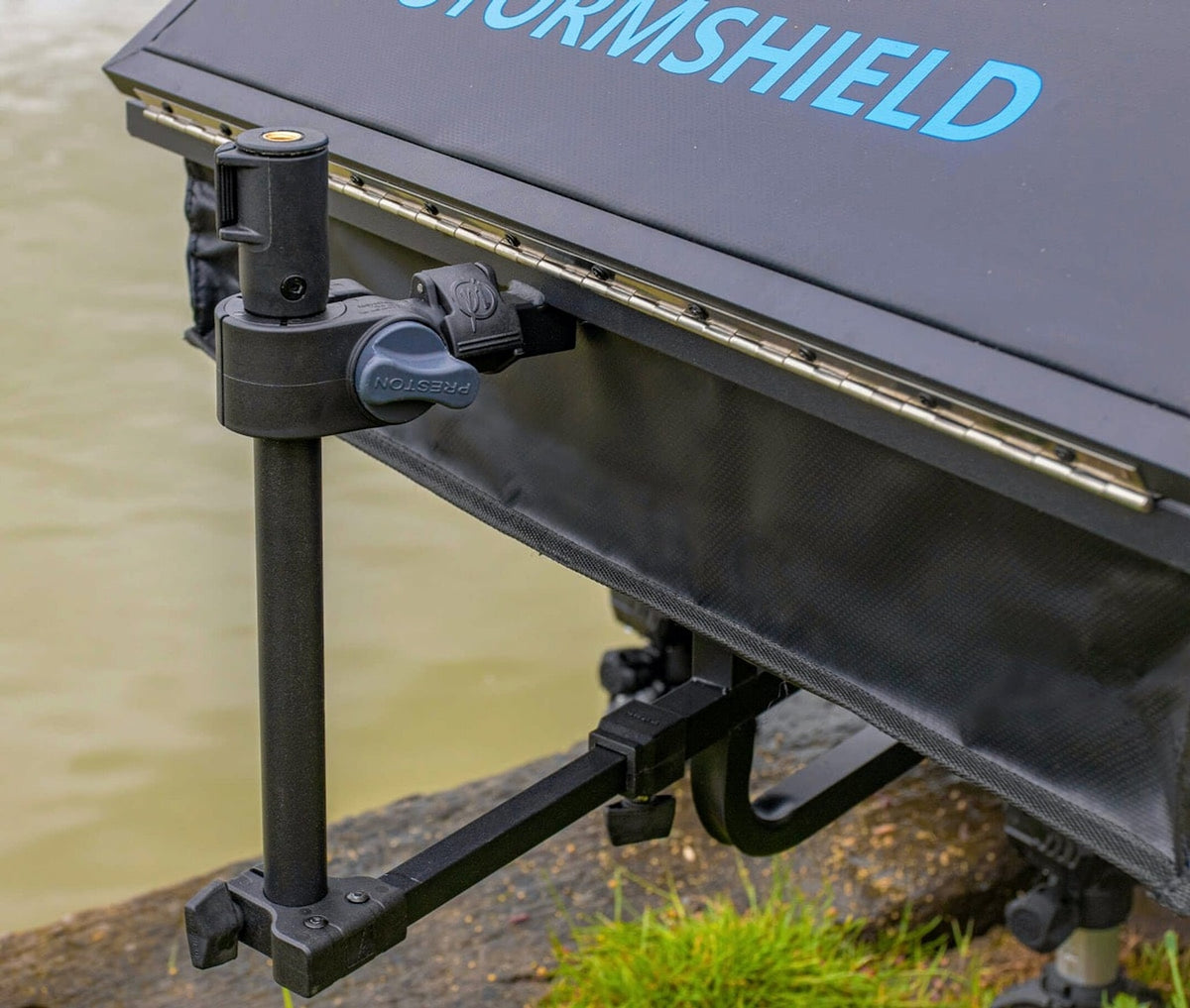 Detail van de verticale accessoirestang en Preston-handknop naast de geopende Stormshield-aastafel