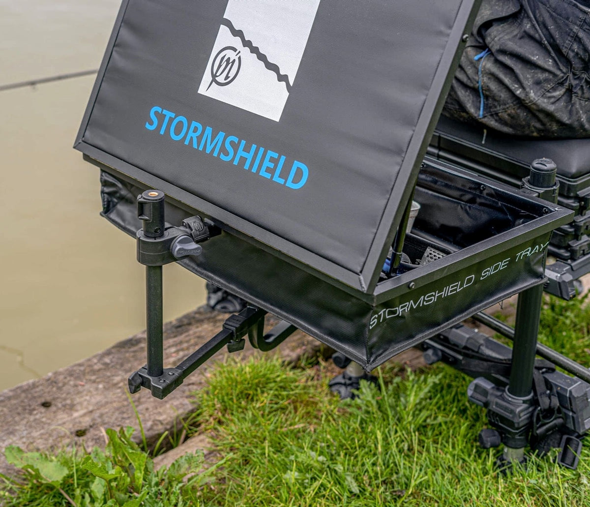 Preston steunarm bij een open Stormshield-aastafel: verticale stang, handknop en steun onder de tafel