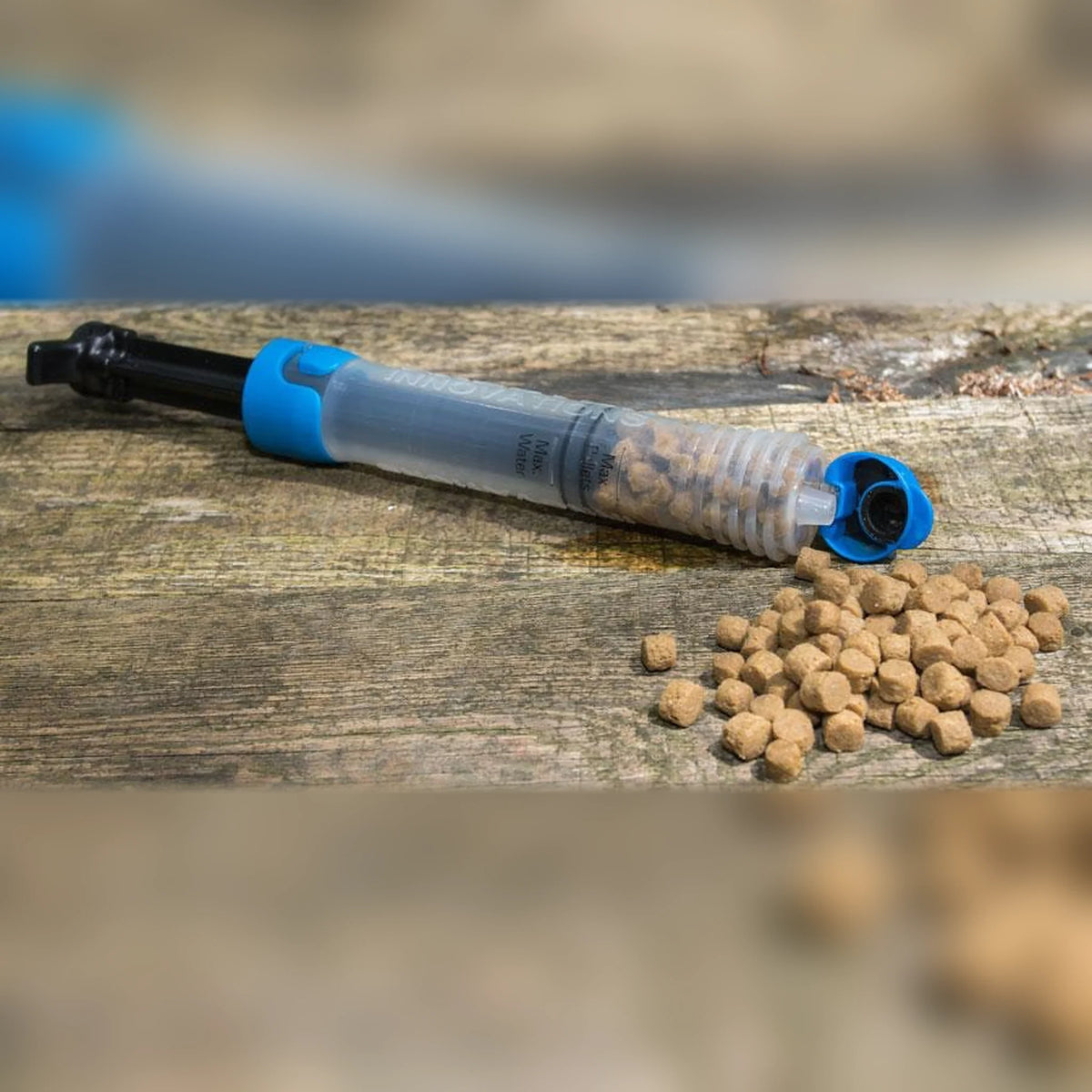 Preston Super Pellet Pump met pellets op een houten ondergrond