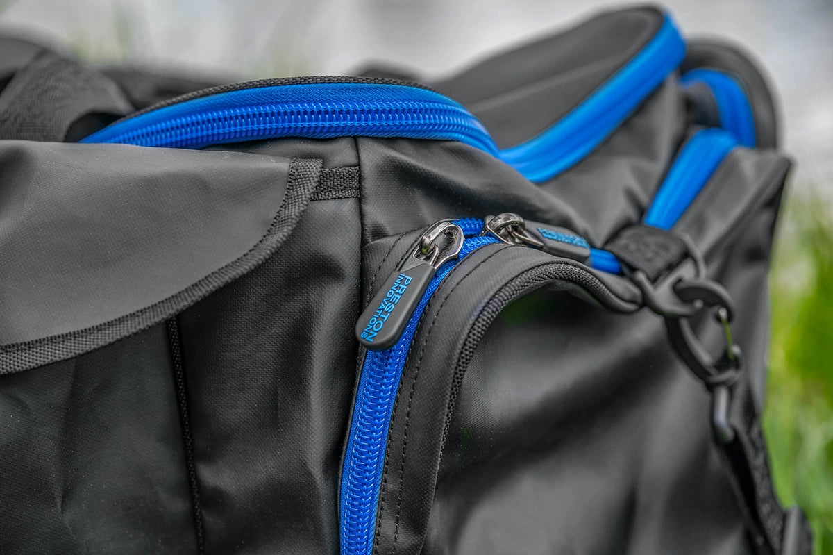 Preston Supera X Carryall met detail van de blauwe ritsen en dubbele ritstrekkers van het zijvak