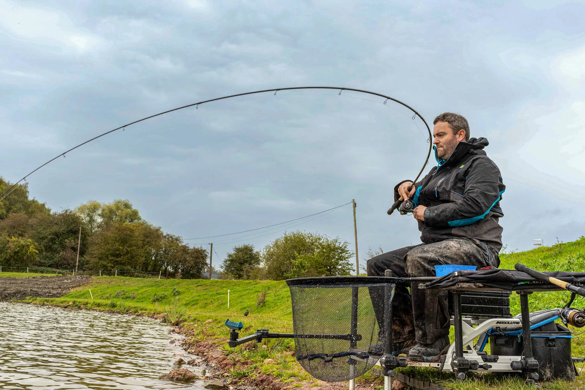 Visser drilt een vis met de Preston Supera X Float-hengel, met de buiging van de hengel zichtbaar