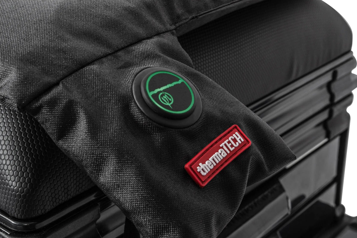 Preston ThermaTech verwarmd zitkussen – detail van de groen verlichte bedieningsknop en het rode ThermaTech-label