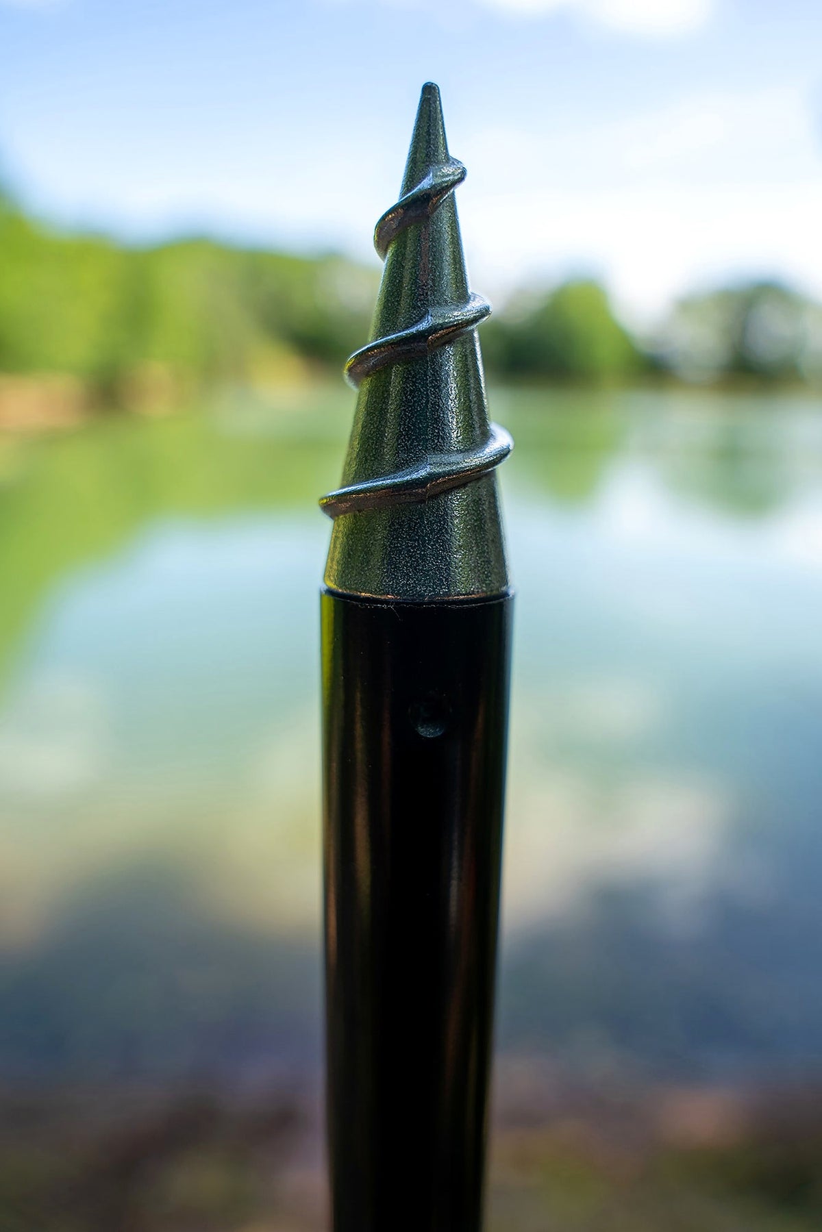 Zebco Trophy Screwpoint Bankstick – schroefpunt in close-up met de waterkant op de achtergrond
